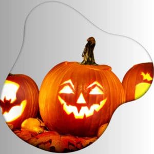 Glowing carved Halloween pumpkins with spooky faces and bat designs on autumn leaves